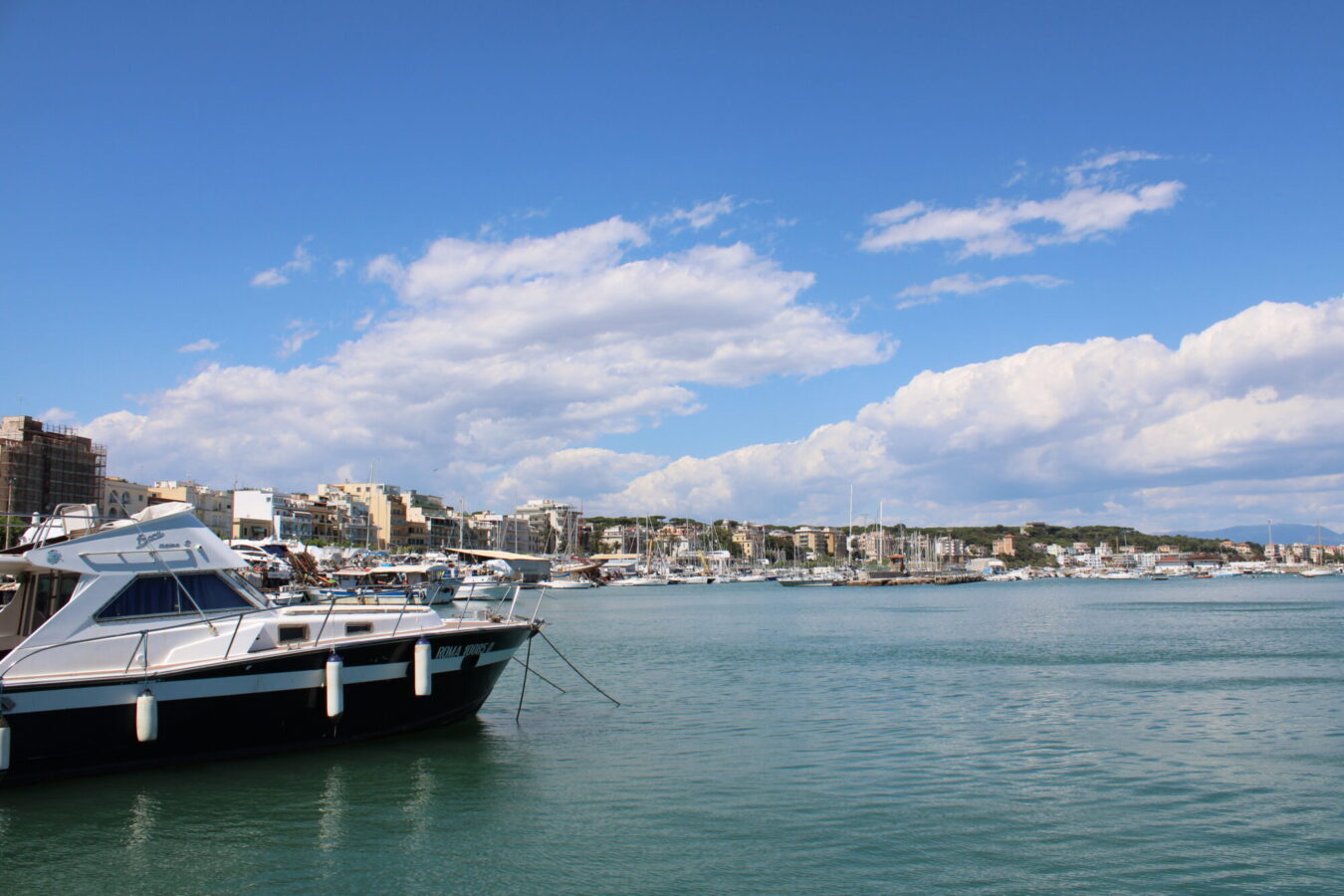 Azure blue water with the city skyline in the background.|A view of the coastal town at sunset with the streets lit up