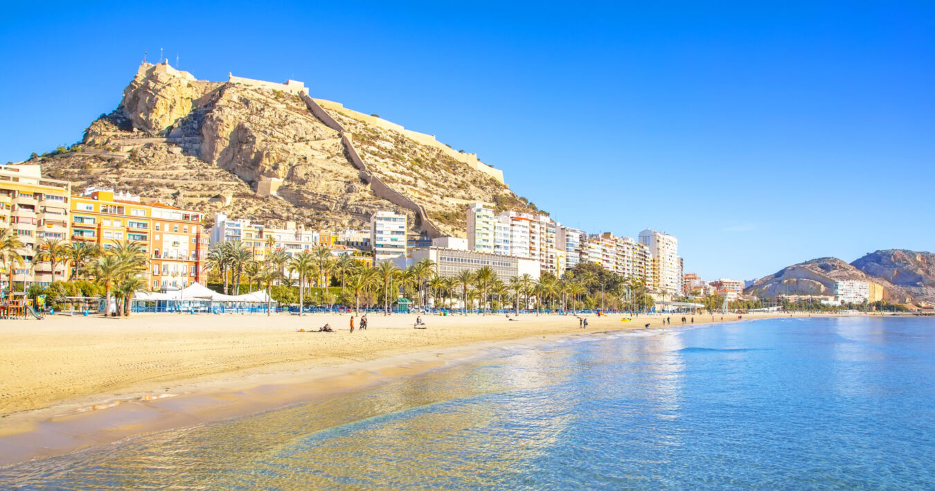Surrounded by palm trees and streetlights.|View from Castillo de Santa Bárbara over the port of Alicante and the Mediterranean Sea.|Beach soccer goals and a solitary palm tree with a view of the sea and distant mountains.